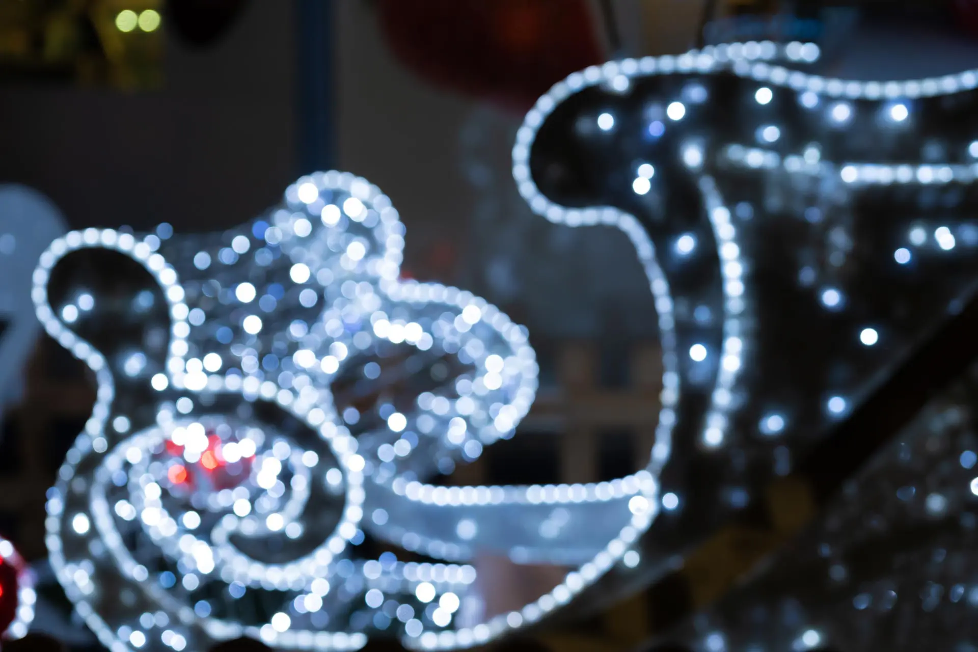 Blurred lights of christmas installation – defocused lights of santa sleigh on night city background. Christmas deer installation in Milan Blurred lights of christmas installation – defocused lights of santa sleigh on night city background. Christmas deer installation in Milan